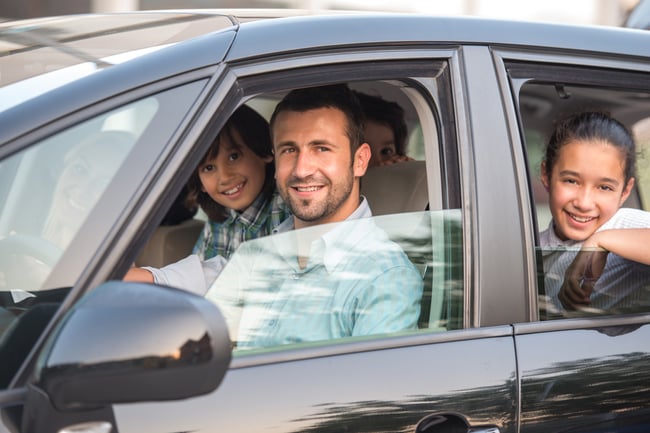 Smiling happy family sitting in car